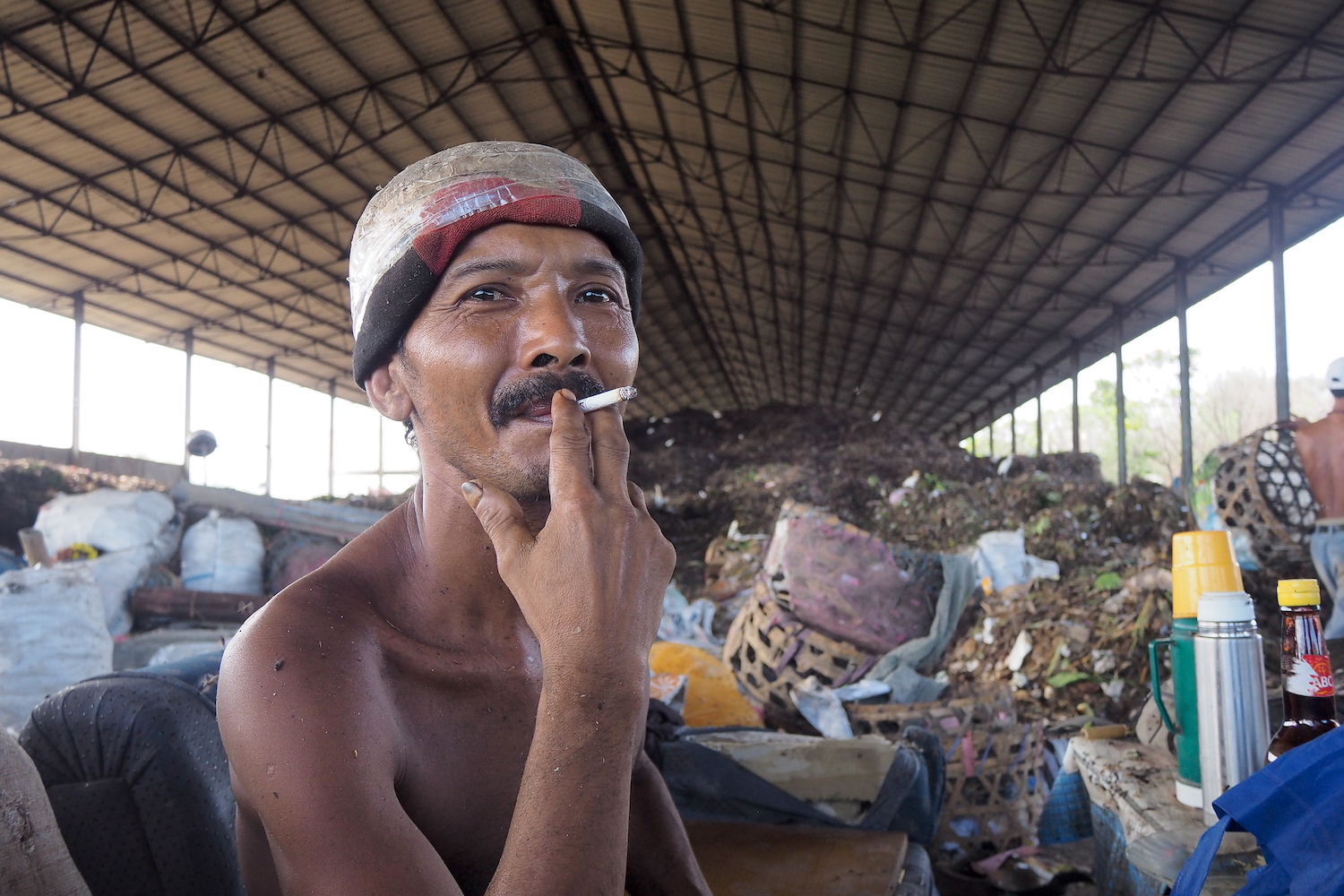 Seorang pekerja TPA Temesi Gianyar beristirahat di antara tumpukan sampah yang difermentasi sebagai bahan baku pupuk organik. Foto Anton Muhajir